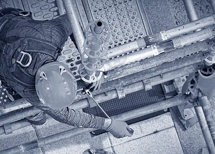 Ein Gerüstbauer beim Aufbauen eines Gerüsts.