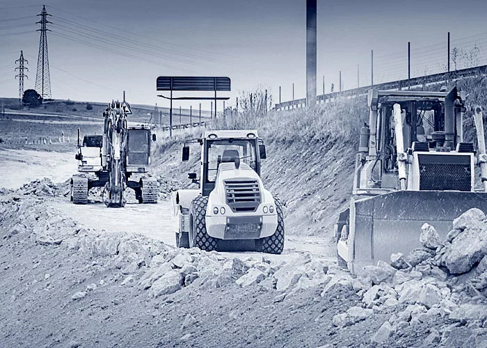 Drei Baustellenfahrzeuge auf einer Baustelle.