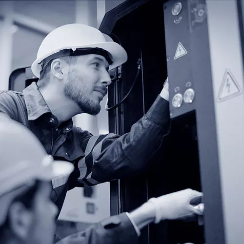 Zwei Industrie-Elektriker bei der Arbeit.