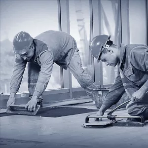 Fliesenleger arbeiten im Team auf einer Baustelle.