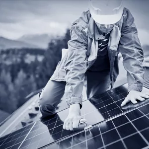 Ein Photovoltaikmonteur befestigt Solarpaneele auf einem Dach.